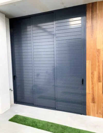 Puerta moderna de exterior con acabado en madera a la derecha