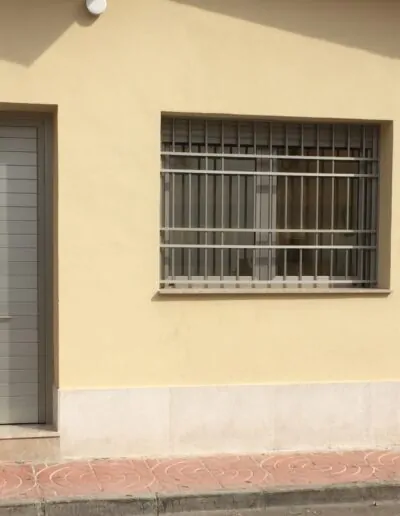 Diseño de puertas y ventana con rejas acabados en un marron grisaceo mate