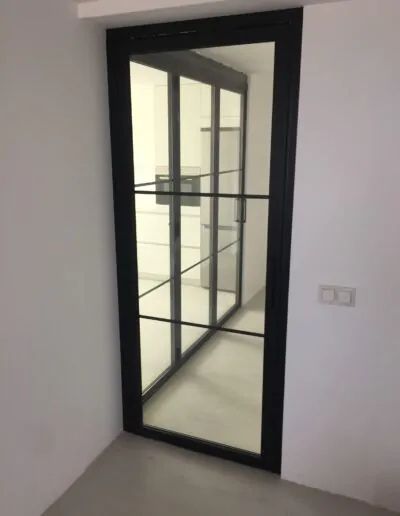 Puerta con cristaleras en acabado en negro con abatible