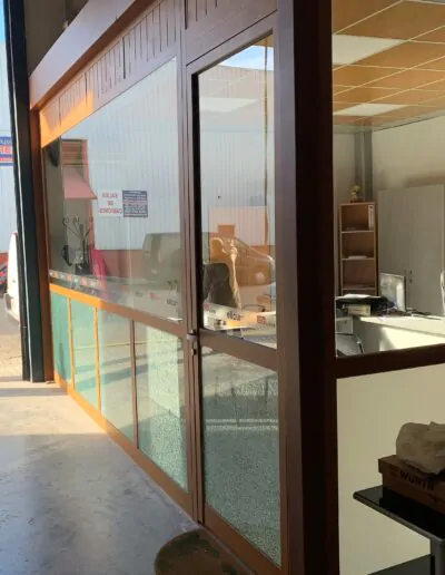 Diseño de puerta exterior con ventanales acabado en marron