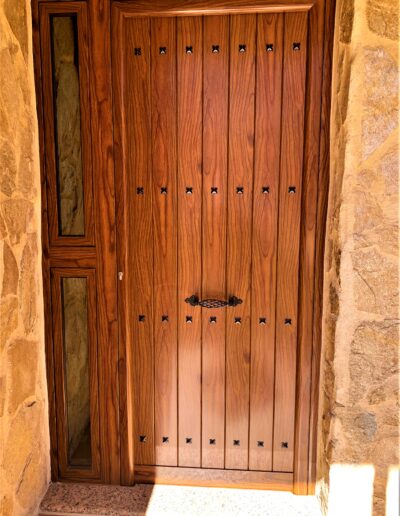 Diseño moderno de puerta con acabado en madera y en la izq. es de cristal