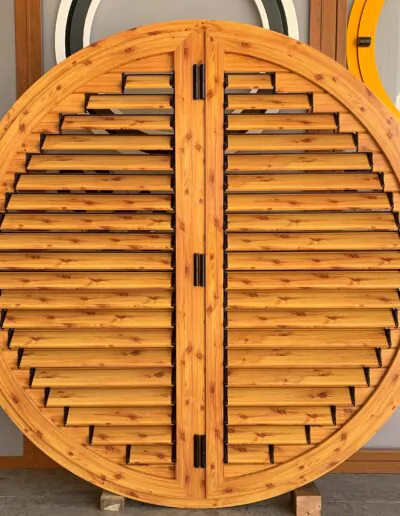 Diseño de ventanal redondo de color madera con persiana fija