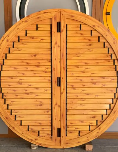 Diseño de ventanal redondo de color madera con persiana fija