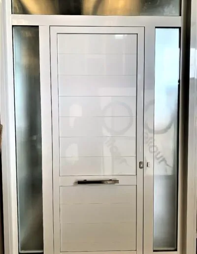 Puerta con acabado blanco y con pequeños ventanales al lado