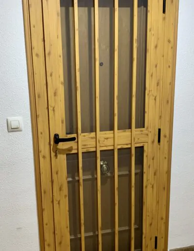 Puerta con acabado de madera con barrotes de seguridad