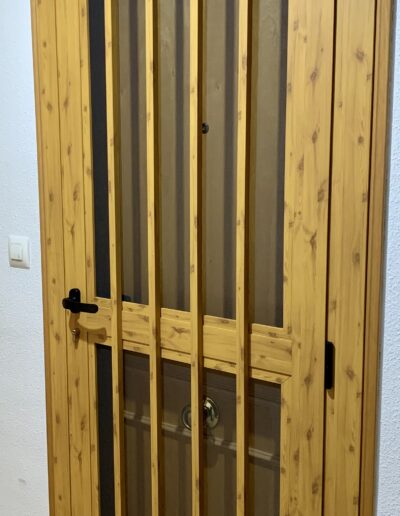 Puerta con acabado de madera con barrotes de seguridad