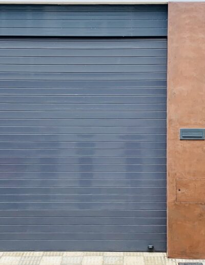 Fachada con garaje y puerta acabado en negro azulado