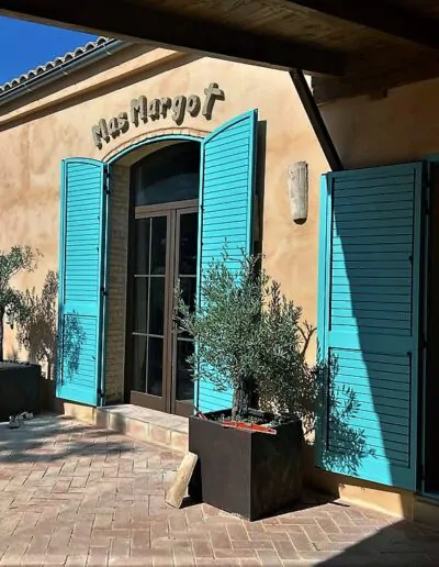Puerta que da al exterior con mecanica de ventanal corredero acabado en azul, con puertas de cristal con acabados de madera