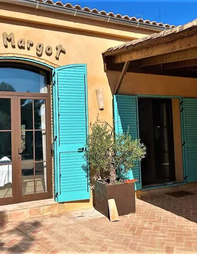 Puerta que da al exterior con mecanica de ventanal corredero acabado en azul, con puertas de cristal con acabados de madera
