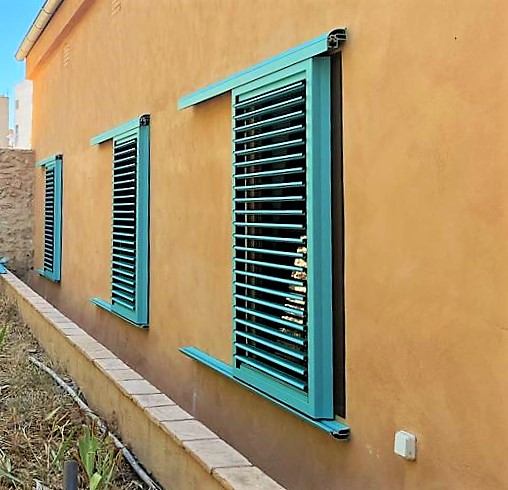 Ventanal que da al exterior con mecanica doble, persiana fija y ventanal corredero acabado en azul